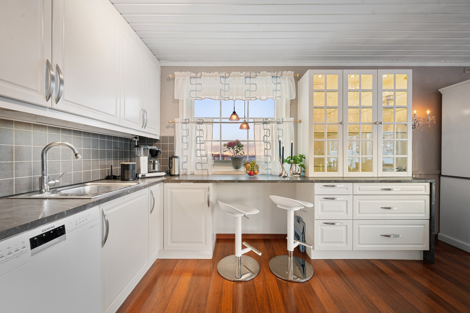 Skap med glassfronter og integrert belysning gir et elegant og gjennomført uttrykk Galleribilde