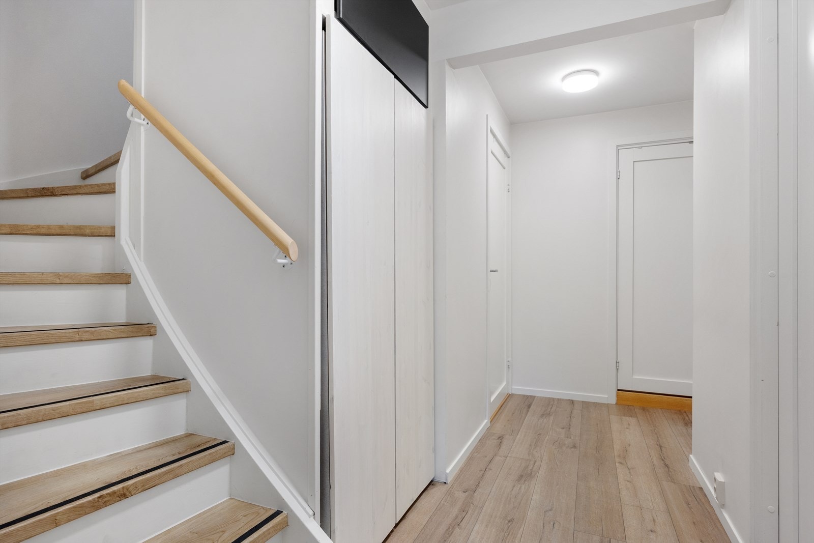 Gang med gulvvarme - Praktisk løsning: Mobilt skap i gangen på hjul, som videre åpner opp mot kott bak/under trappen. Galleribilde