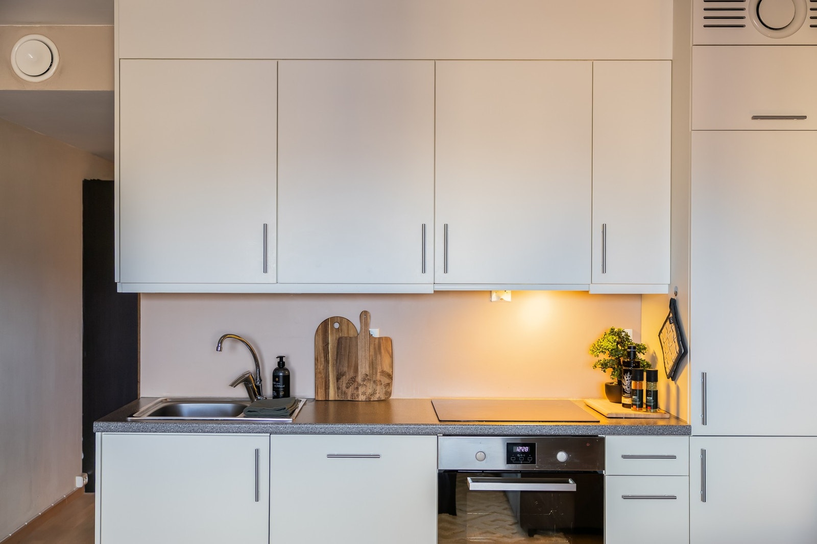 Tidløst kjøkken fra Osmo med hvite fronter og mørk benkeplate. Galleribilde