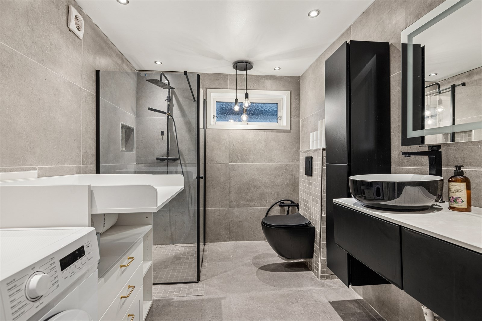 Lekkert baderom renovert i 2022. Badet er innredet med store, grå fliser på gulv og vegger. Galleribilde