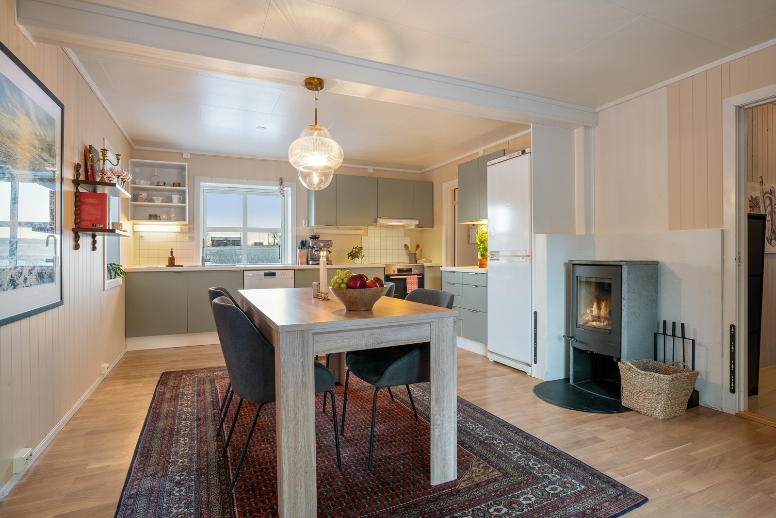 Rommet er utstyrt med frittstående hvitevarer som oppvaskmaskin, komfyr med platetopp og et praktisk kjøl-fryseskap og en klebersteinovn. Galleribilde