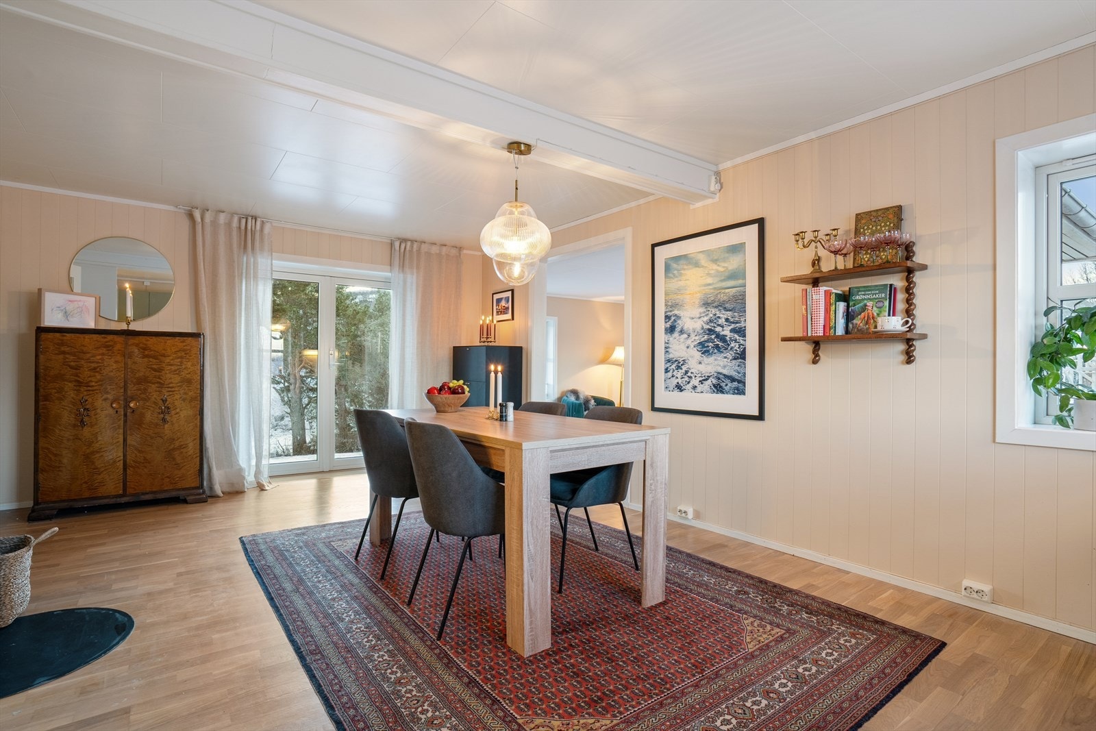 Planløsningen er åpen mot en innbydende spiseplass, perfekt for hyggelige måltider og samvær. Fra kjøkkenet fører doble terrassedører rett ut til hagen - en herlig forlengelse av rommet på varme dager, og en fin måte å slippe inn mye dagslys hele året. Galleribilde