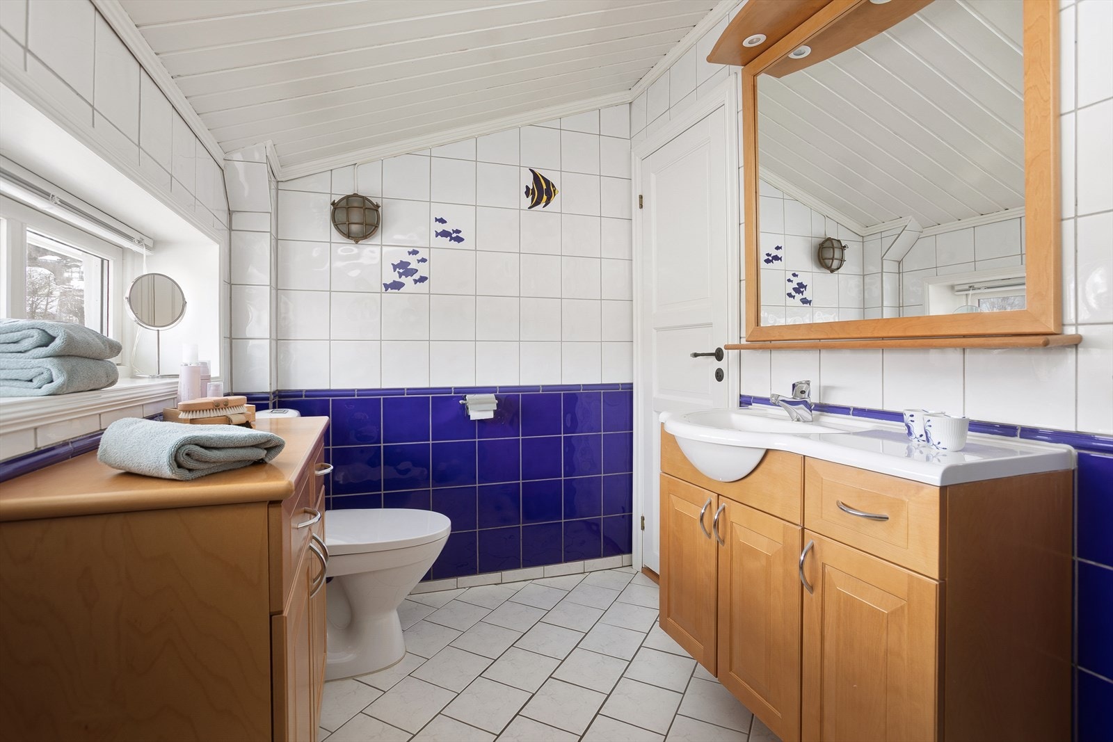 Badet er utstyrt med heldekkende servant med underskap, speil med lys, dusjnisje med innfellbare dører, toalett og bide Galleribilde