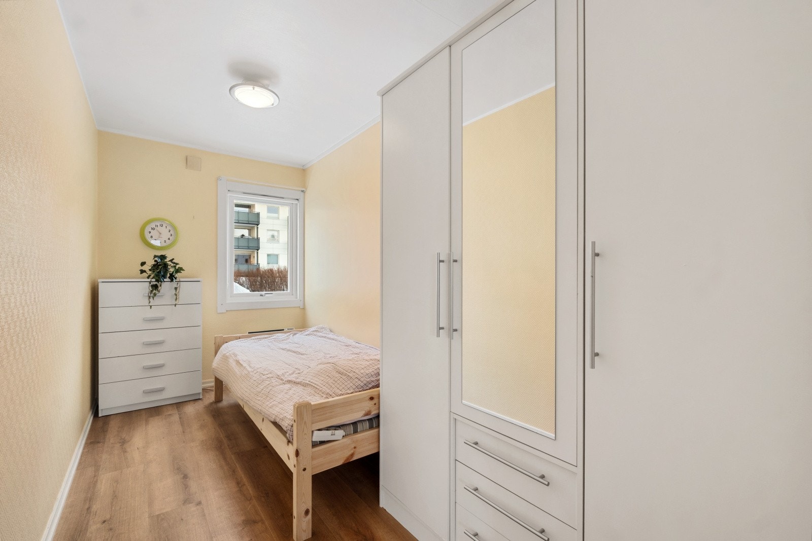 Lyst og fin soverom med plass til enkel seng, skap og romslig garderobe. Galleribilde