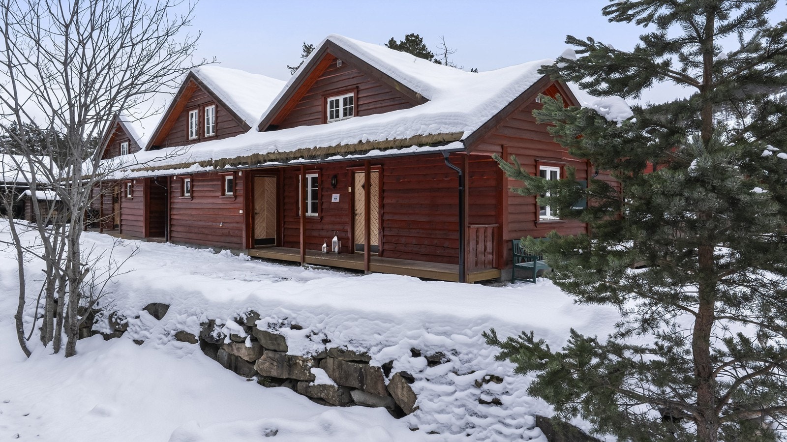 Det er parkering på utsiden av hytteveggen Galleribilde
