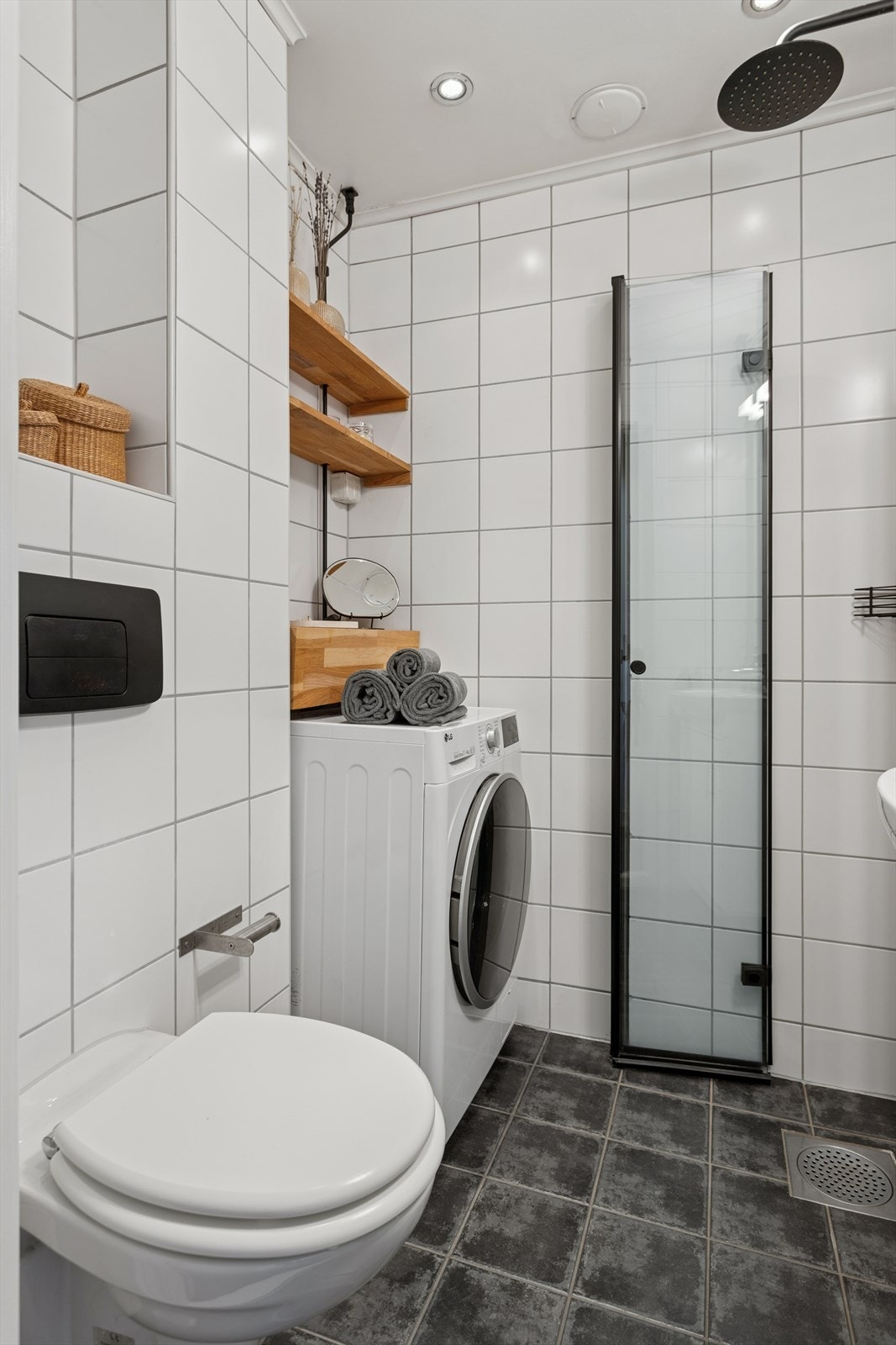 Innredet med vegghengt servant, toalett, dusjhjørne og opplegg for vaskemaskin Galleribilde