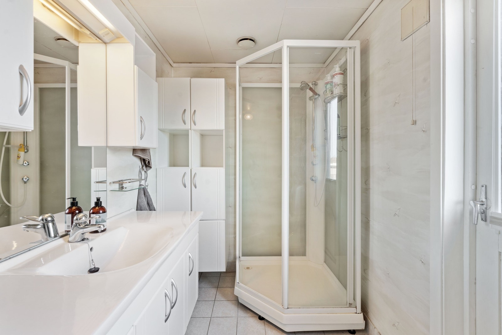 Ellers er badet utstyrt med dusjkabinett, vegghengt baderomsmøbel og gulvstående toalett. Galleribilde