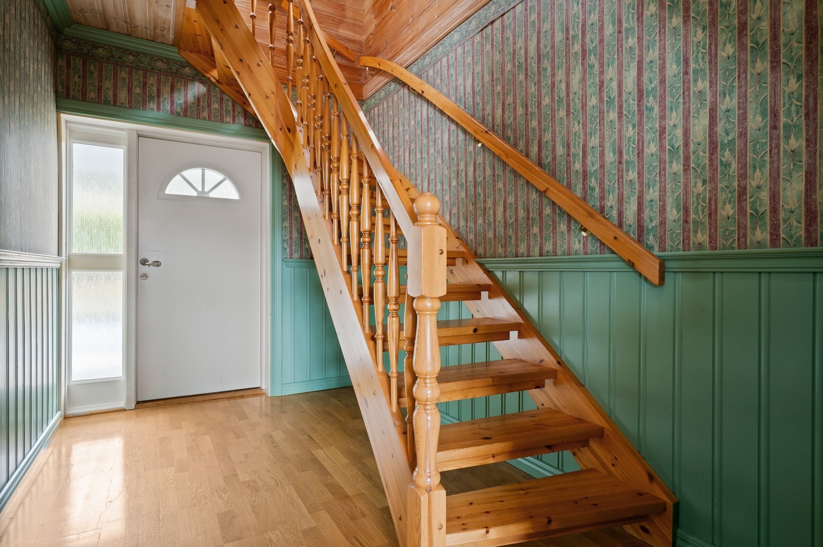 Inngangspartiet har en solid tretrapp som fører opp til andre etasje. Galleribilde