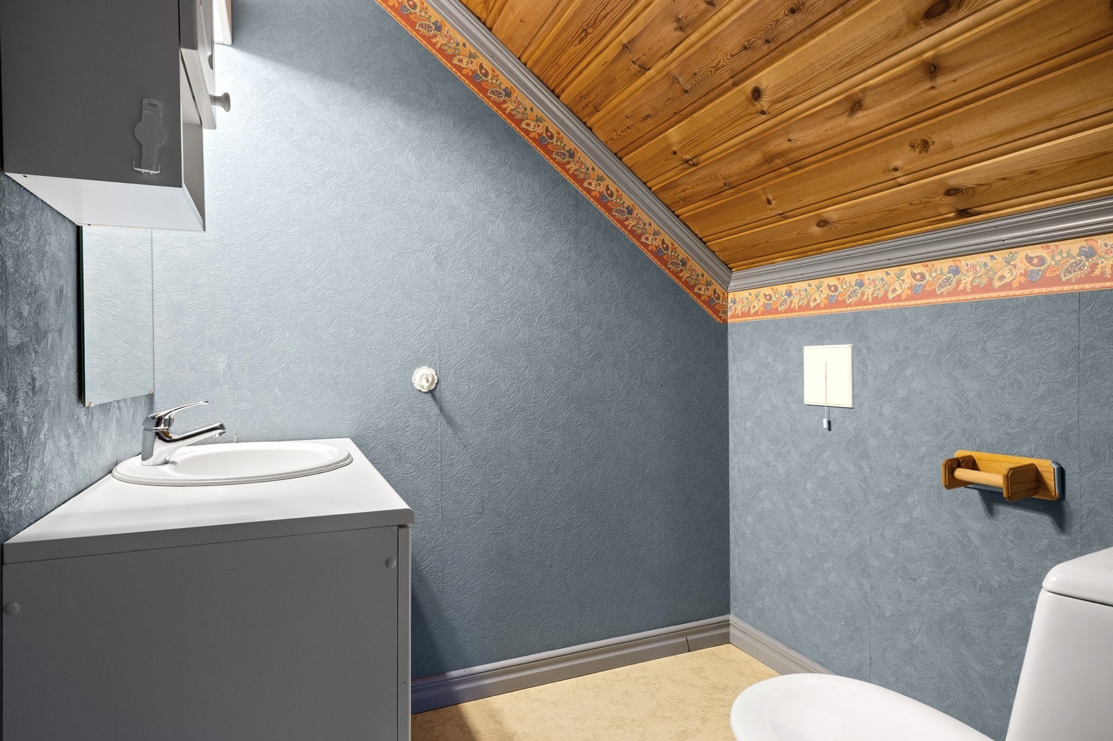 Toalettrom i andre etasje med servant, toalett og skråtak. Galleribilde