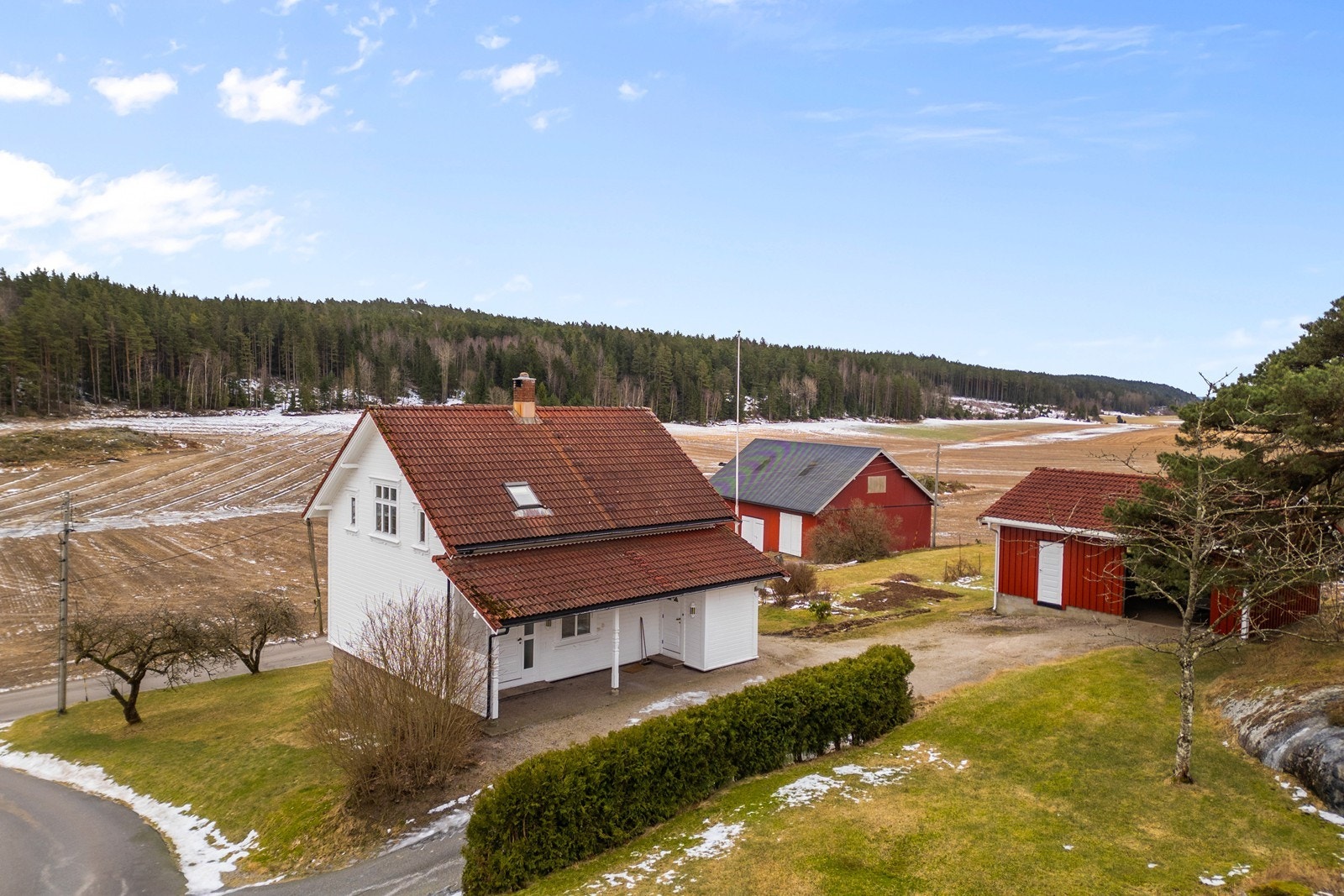 Eneboligen ligger fint til på tomten med en velstelt hekk mot gårdsplassen. Galleribilde