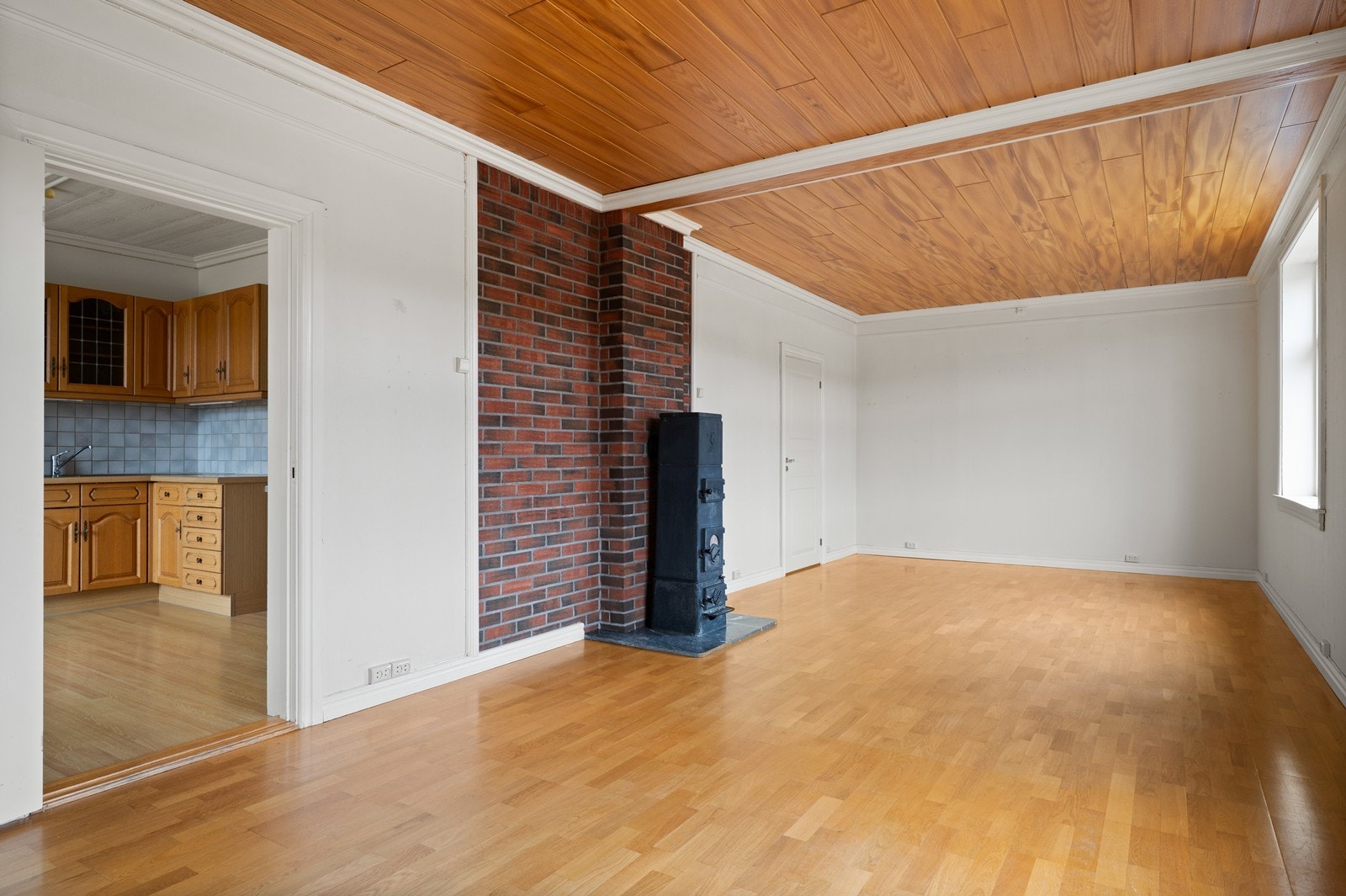 En klassisk vedovn er sentralt plassert i rommet og gir mulighet for ekstra varme. Galleribilde