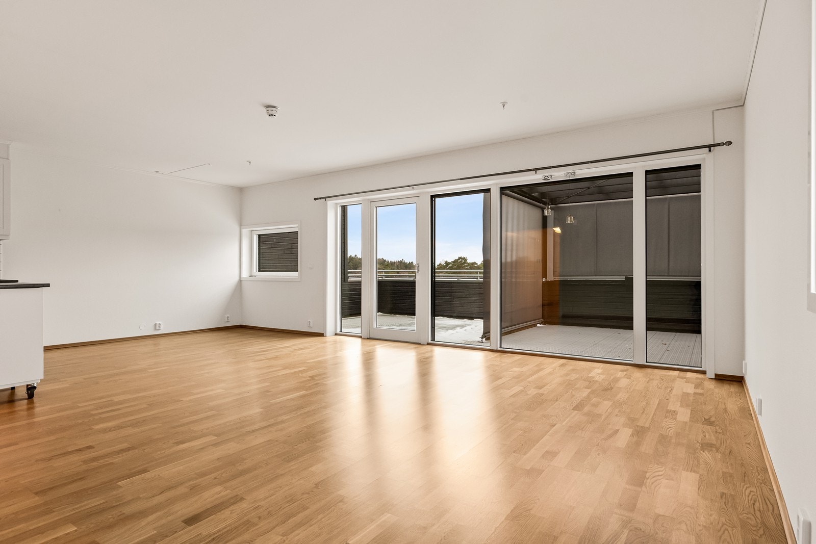 Stuen har en åpen og harmonisk løsning mot kjøkkenet, og er malt i lyse farger som matcher gulvene og skaper en behagelig og romslig atmosfære. Galleribilde