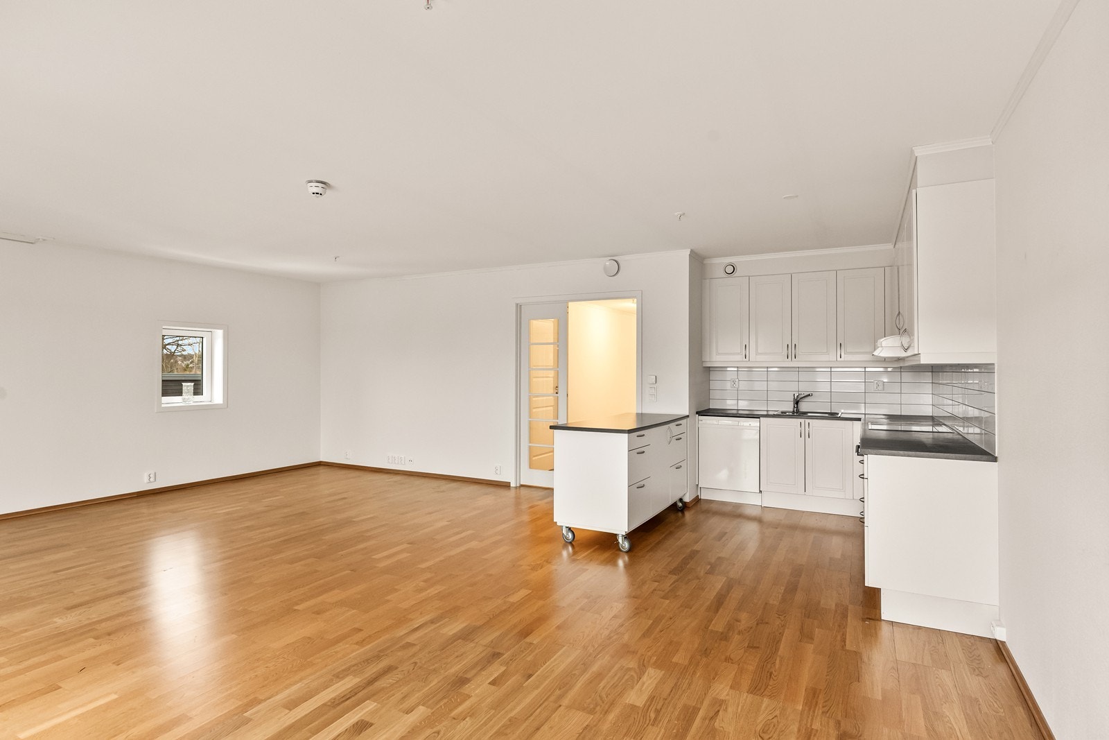 En flyttbar kjøkkenøy på hjul gir ekstra arbeidsplass og fleksibilitet i planløsningen, og det er god plass til spisebord i tilknytning til kjøkkensonen. Galleribilde