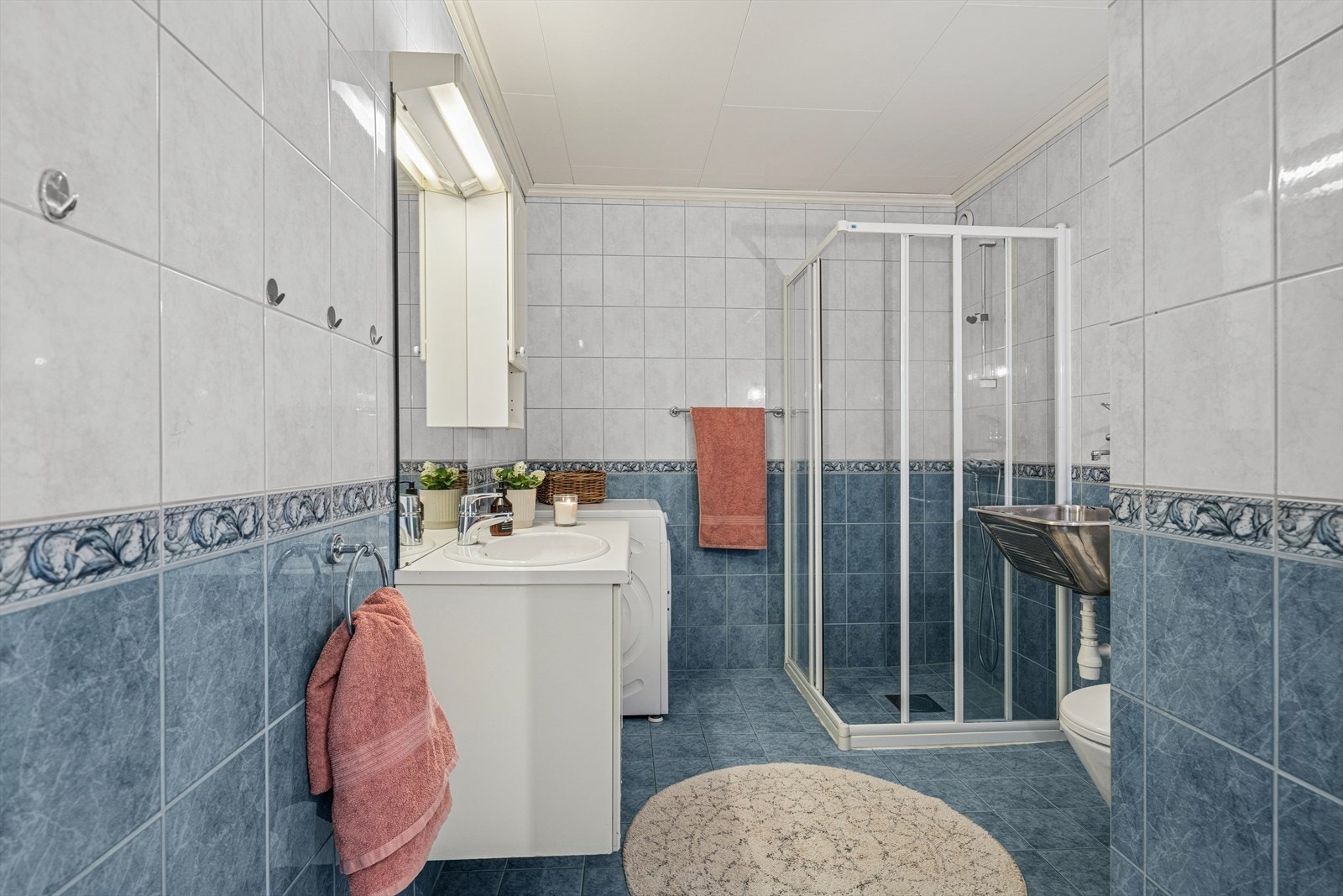 Badet er fra byggeåret og har fliser på veggene og et flislagt gulv med elektriske varmekabler. Galleribilde