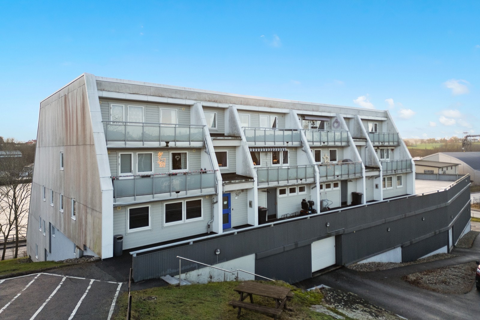 Bygningen har fasader med en kombinasjon av plater og trekledning. Galleribilde