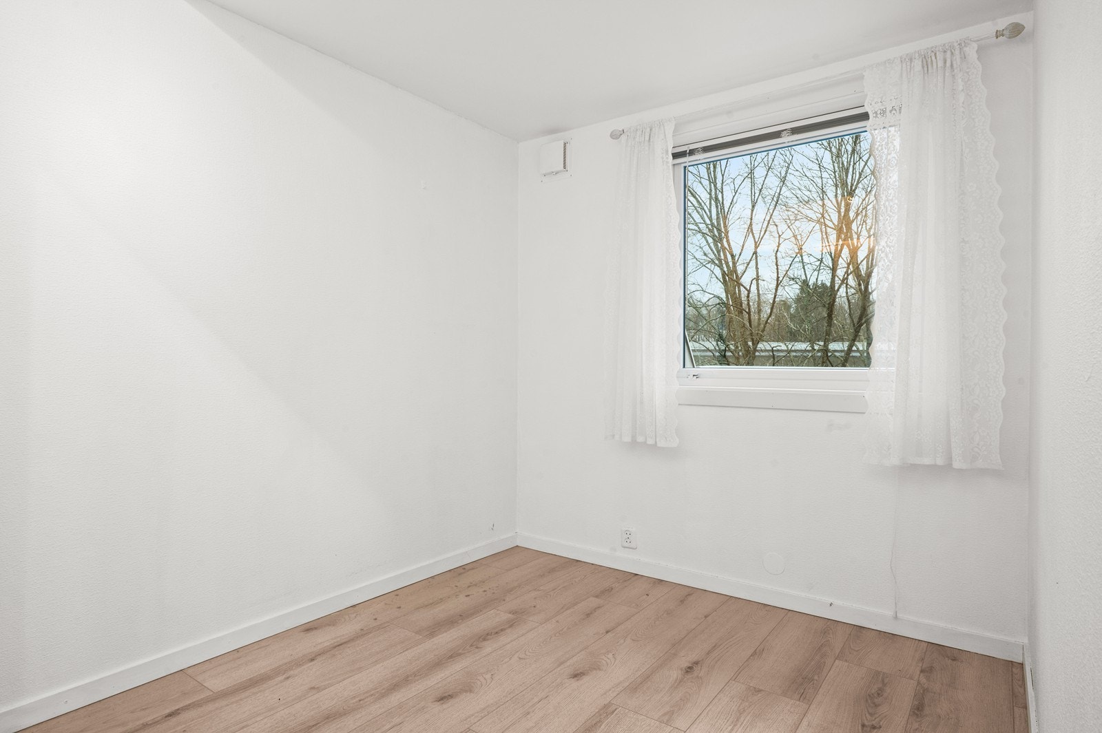 Soverom med laminatgulv og malte, slette flater på vegger og i himling, med plass til seng og nattbord. Galleribilde