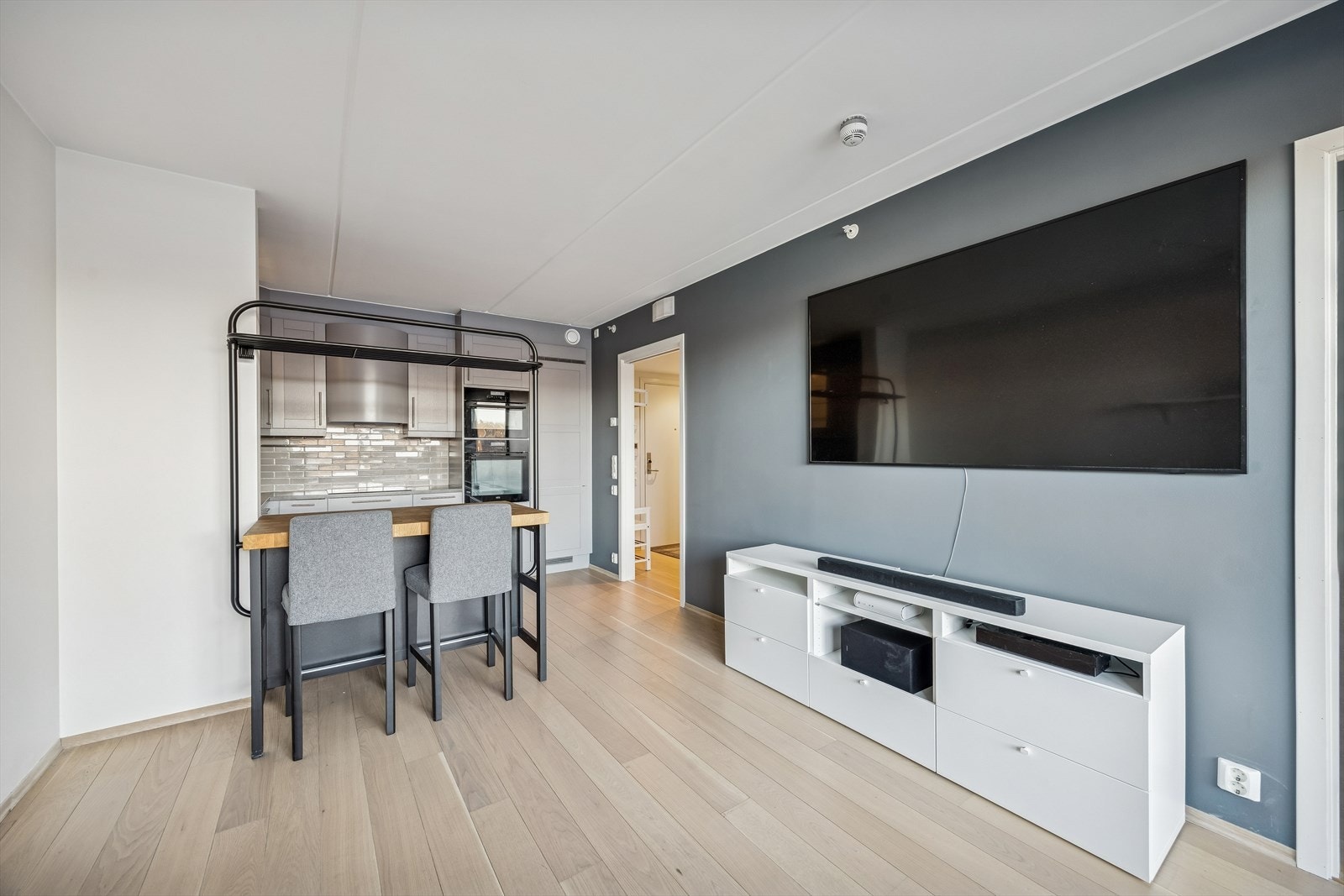 Den sosiale sonen mellom stue og kjøkken gir en naturlig samlingsplass. Tv m/benk og høyttalere medfølger. Galleribilde