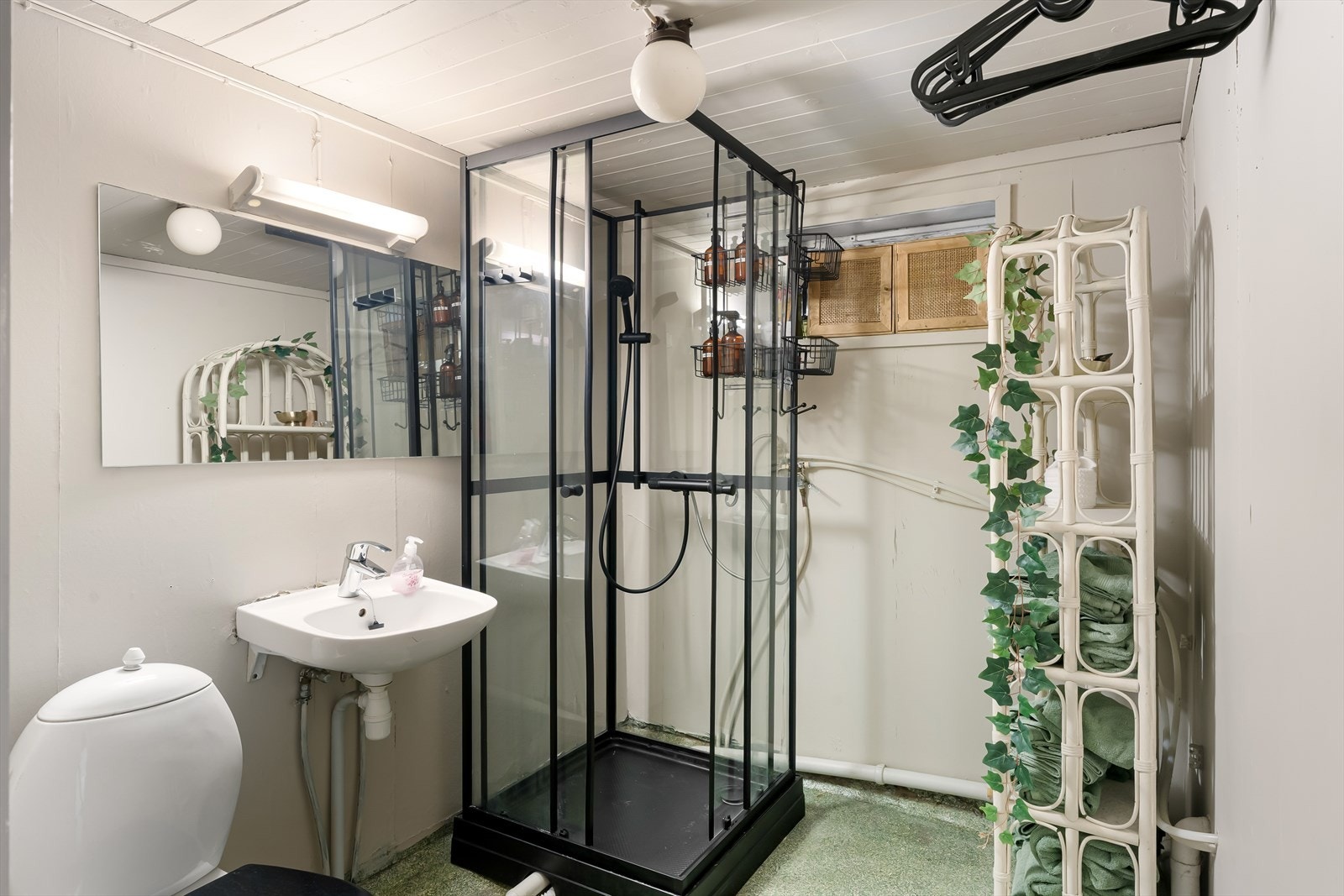 Lyst og funksjonelt bad med dusjkabinett og praktisk innredning Galleribilde