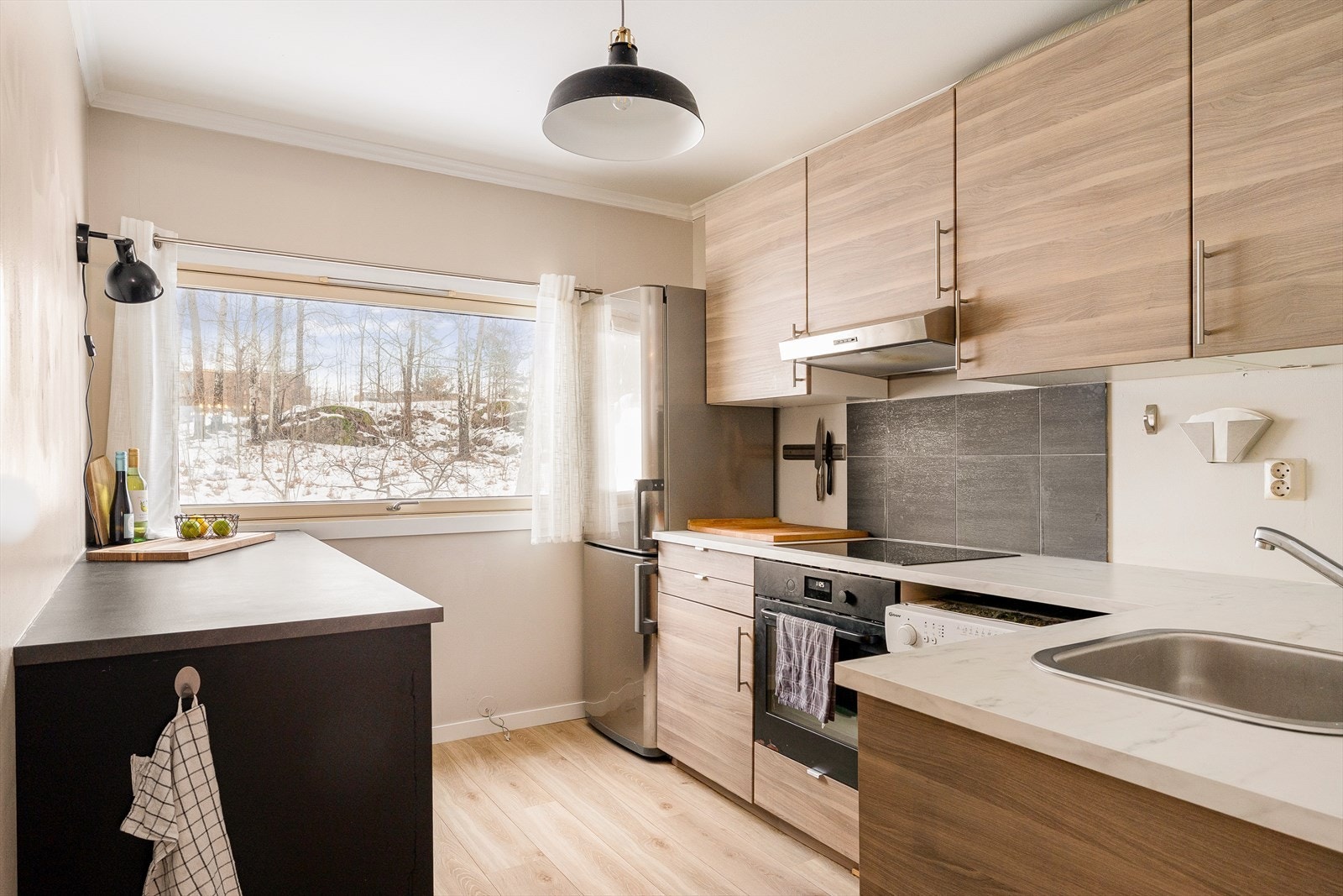 Kjøkkenet byr på rikelig med både benke- og skapplass, slik at du får gode arbeidsflater og praktisk oppbevaring som gjør hverdagen enklere og mer oversiktlig. Galleribilde