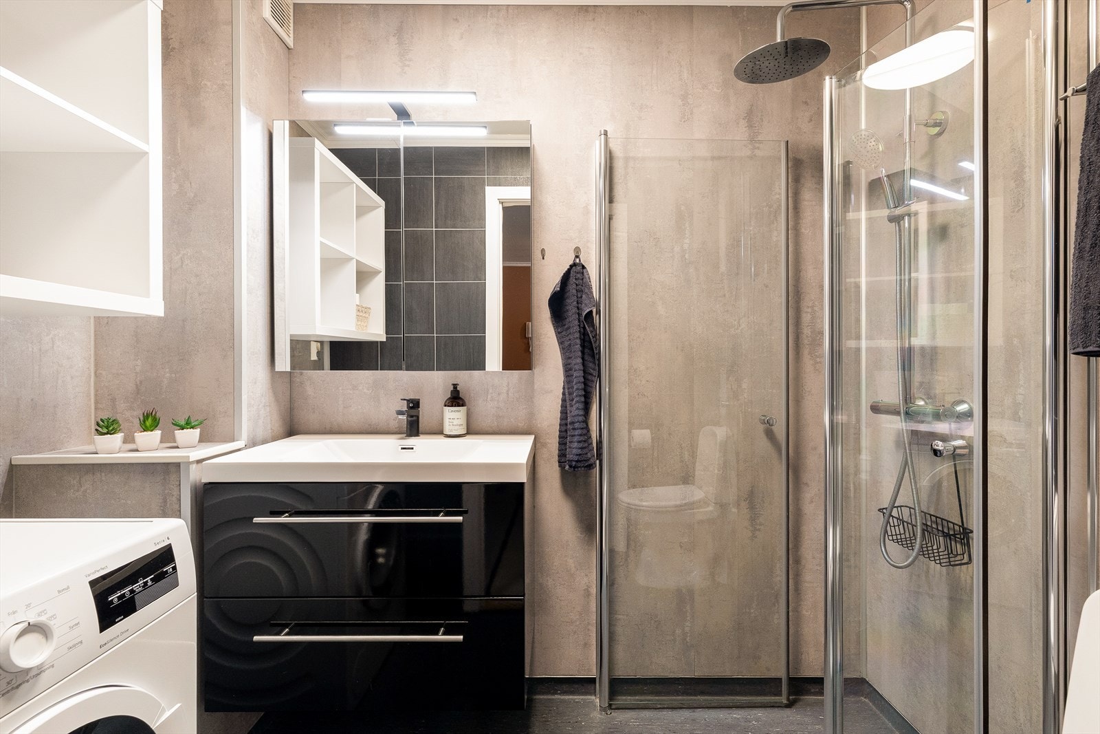 Pent og tidløst bad/vaskerom som ble oppusset i 2020. Rommet fremstår moderne og praktisk, med god plassutnyttelse, opplegg for vaskemaskin og kvalitetsmaterialer som gir et friskt og innbydende uttrykk. Galleribilde