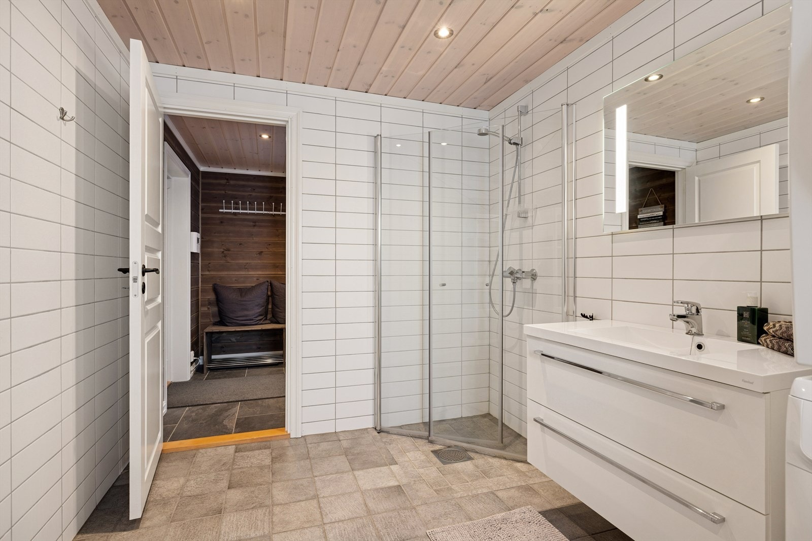 Praktisk og romslig bad nummer to
Badet har god størrelse med gjennomtenkt oppbevaringsplass, og er godt tilrettelagt for praktisk bruk. Her er også opplegg for vaskemaskin og tørketrommel, noe som gjør hverdagen på hytta enkel og komfortabel. Galleribilde