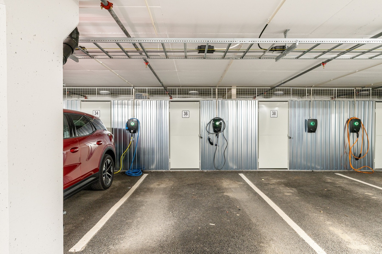 Egen parkeringsplass i lukket anlegg med elbil-lader og bod bak parkeringsplassen. Galleribilde