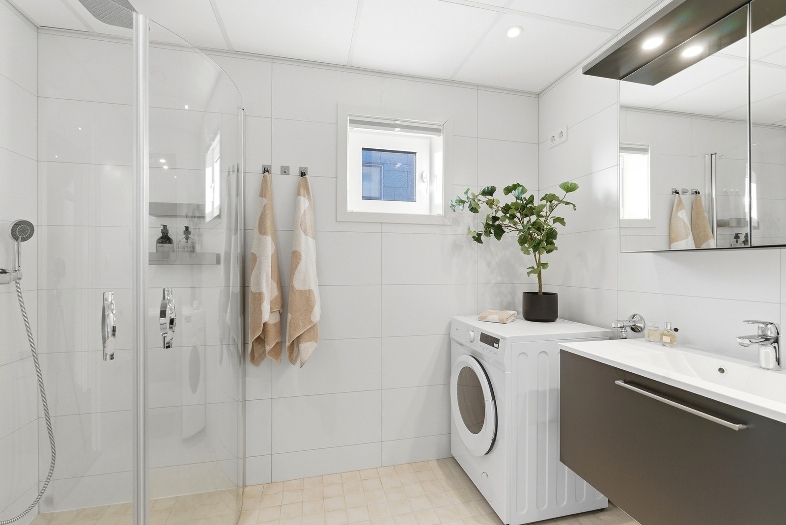 Flott flislagt bad med varmekabler i gulv og downlights i himling. Dusjhjørne med innfellbare vegger. Hånddusj og regnfallsdusj. Galleribilde