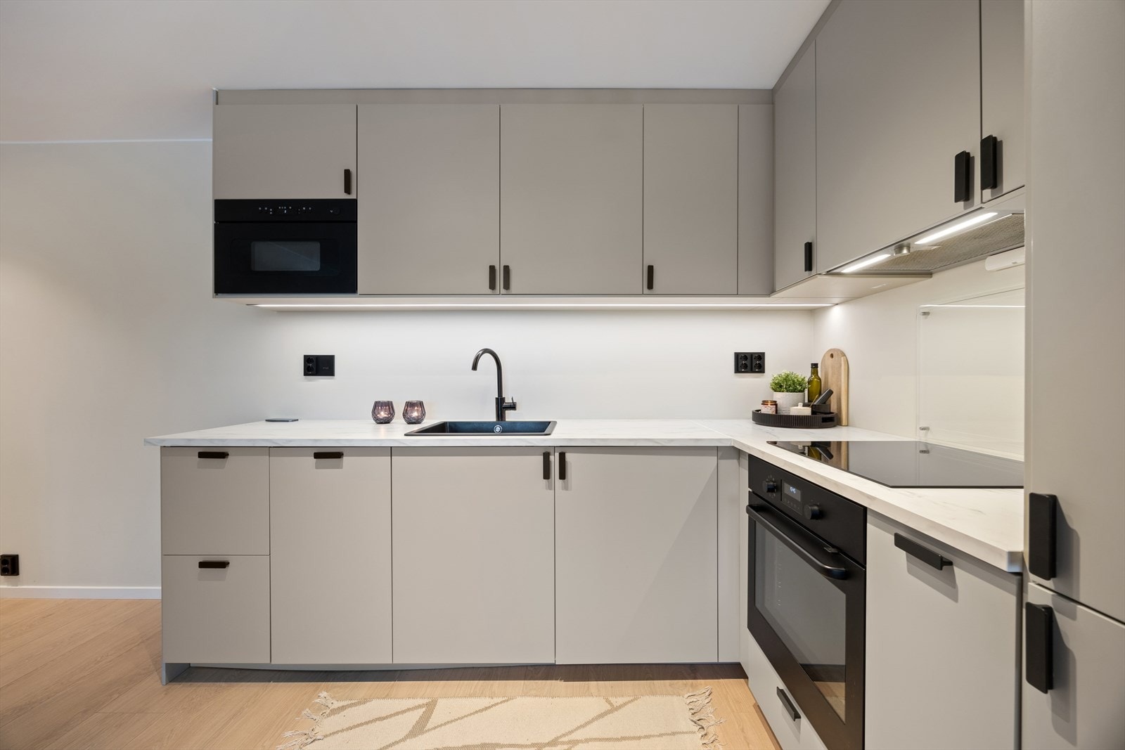 Moderne og stilrent IKEA-kjøkken fra 2025 i åpen løsning mot stuen, med meget god utnyttelse av plassen. Kjøkkenet har glatte fronter og laminat benkeplate. Galleribilde