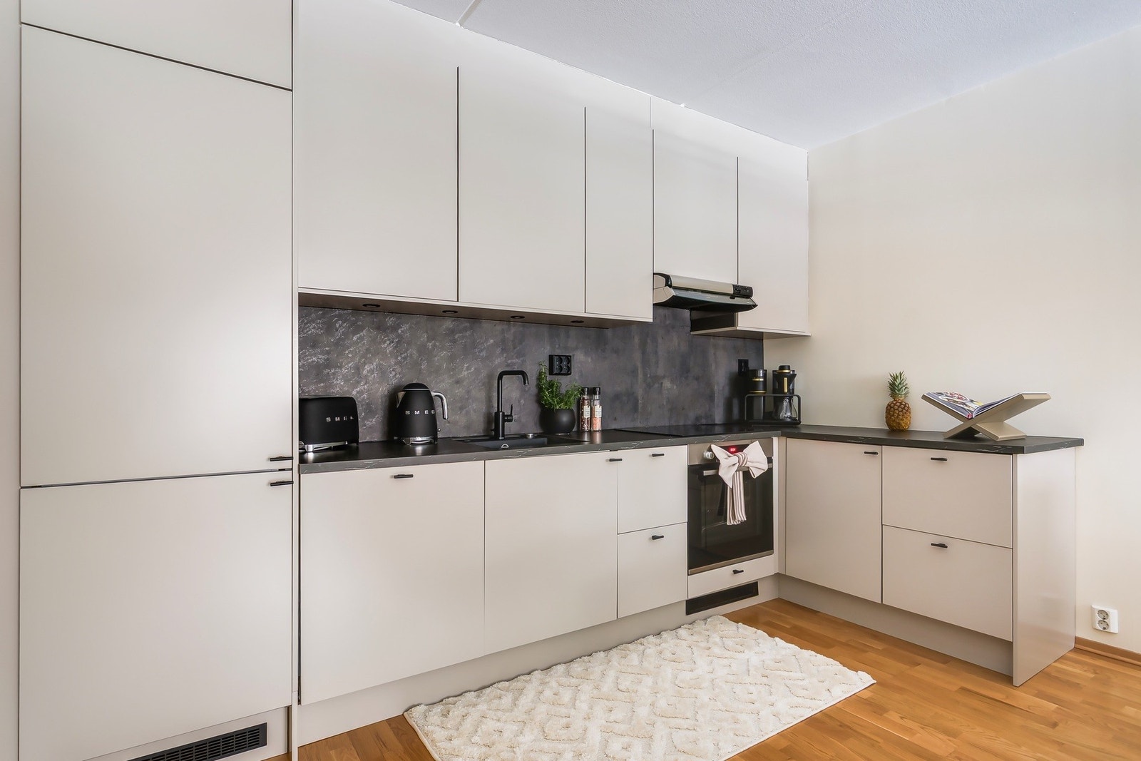 Rålekkert epoq kjøkken fra 2023. Kjøkkenet har glatte fronter, laminert benkeplate med integrert kjøkkenkum.
Plate på vegg over kjøkkenbenk. Integrerte hvitevarer med innfelt platetopp i benkeplate, oppvaskmaskin, komfyr og kjøl/frys. Galleribilde