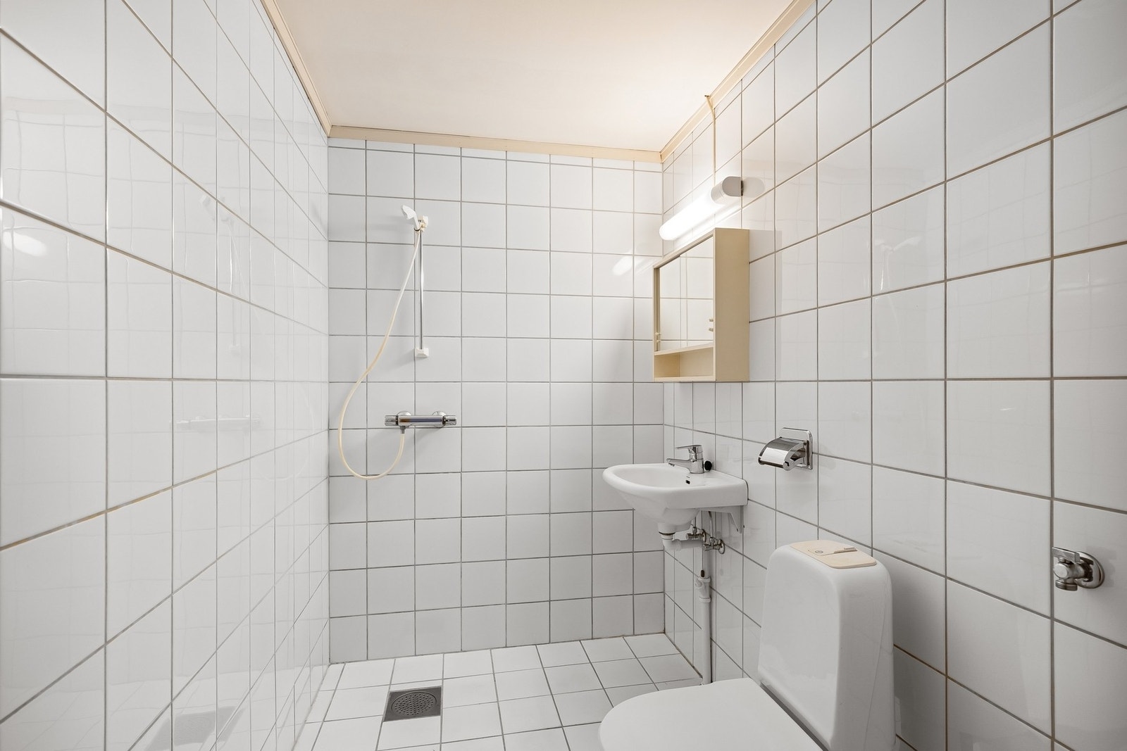 Lyst flislagt baderom med varmekabler i gulvet Galleribilde