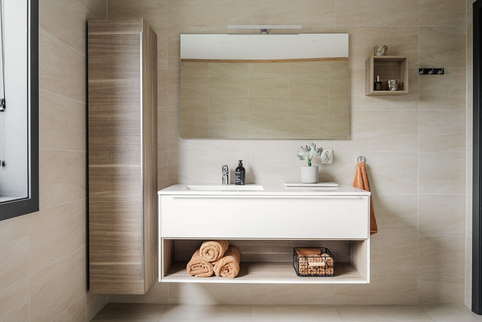 Stilren og lekker baderomsinnredning med heldekkende servant, stort speil med belysning over. Ekstra vegghengt høyskap gir god oppbevaringsplass. Galleribilde