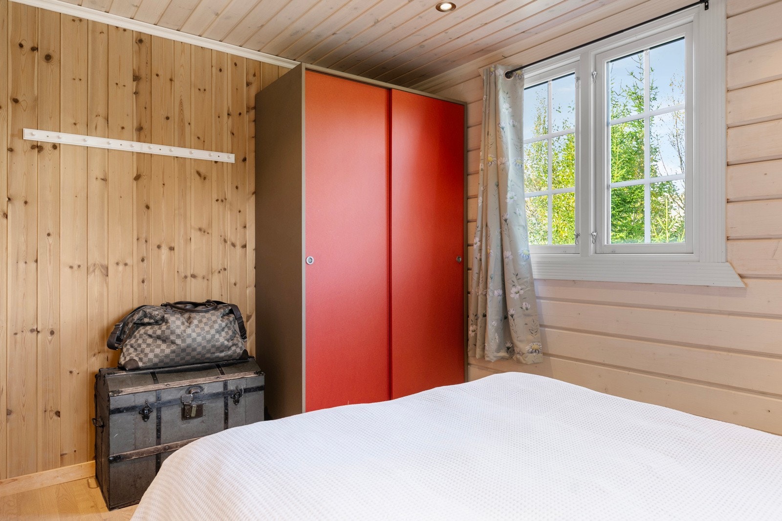 Rommene har synlig tømmer og panel på vegger, parkett på gulv og store vinduer som slipper inn rikelig med lys. Galleribilde