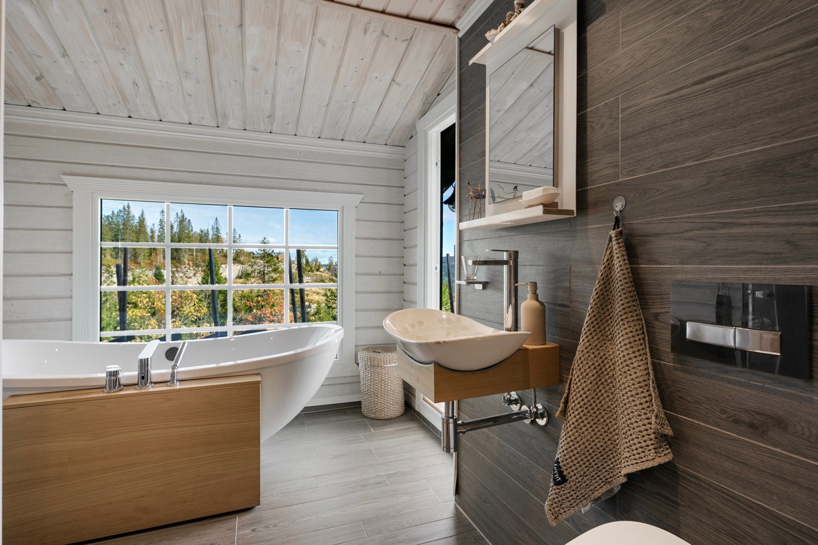 Romslig bad med flislagt gulv med gulvvarme og veggflater av synlig tømmer, panel og fliser Galleribilde