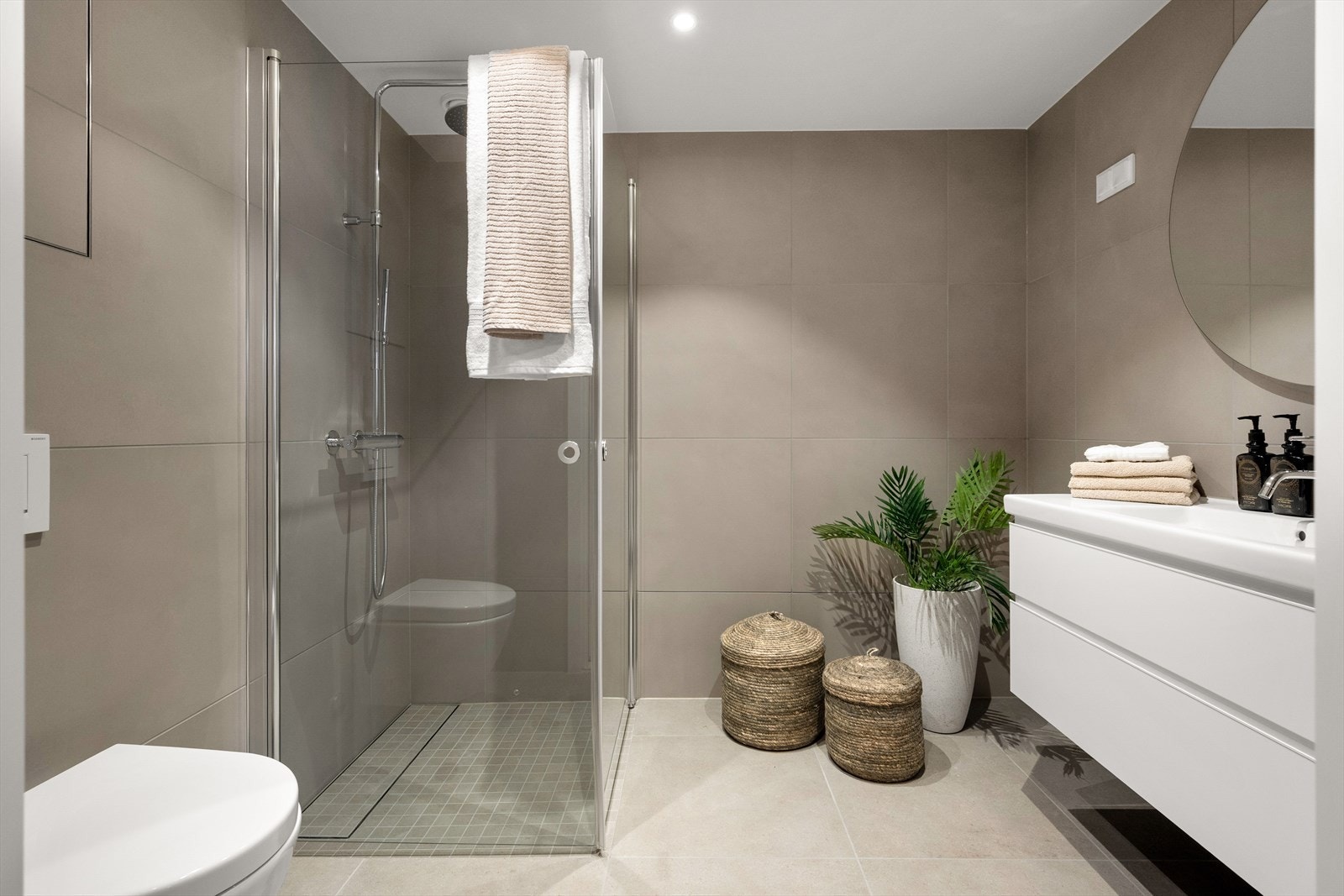 Lekkert flislagt baderom med varmekabler i gulv og downlights i himling Galleribilde