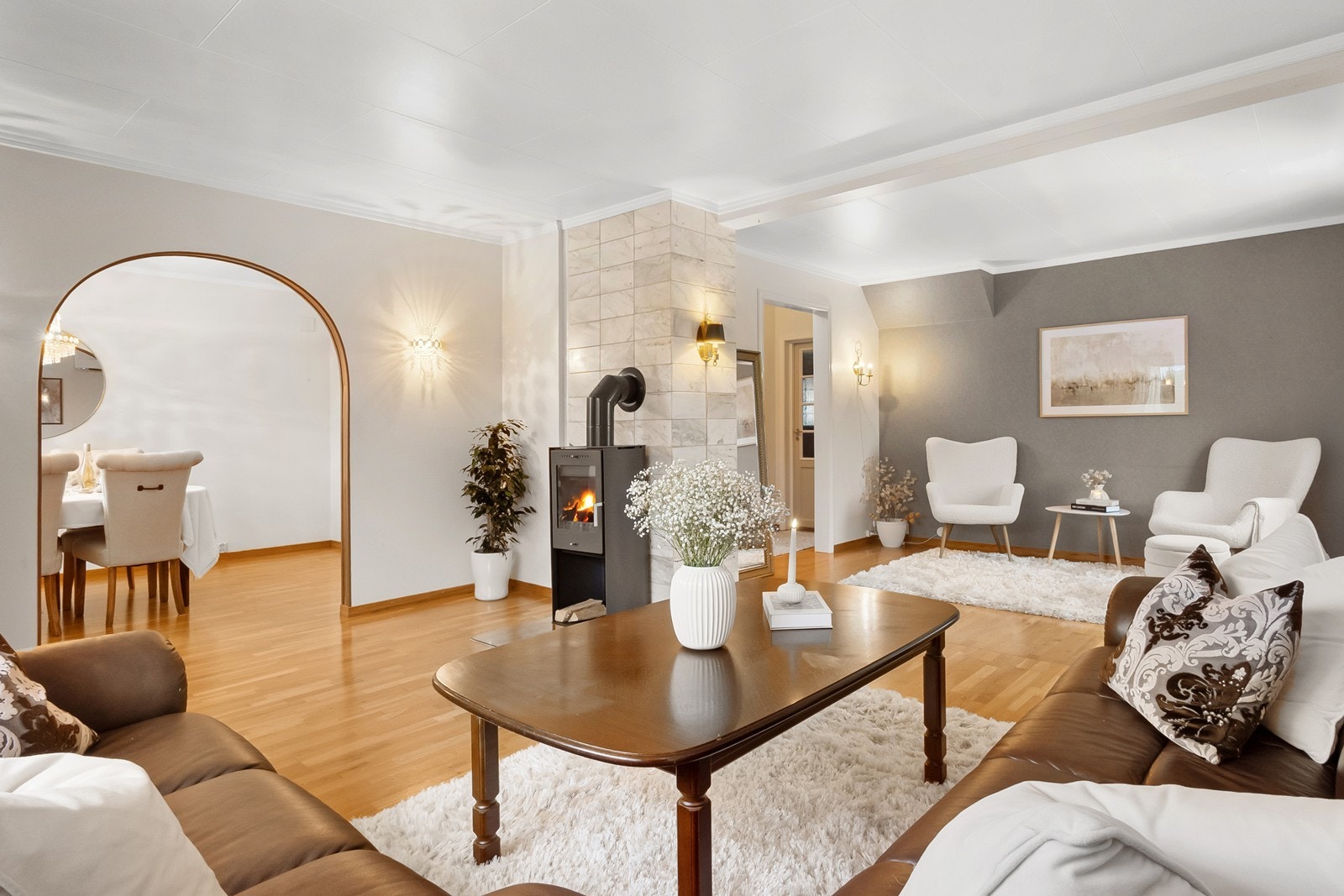 Via en bueåpning videreføres stuen sømløst inn i spisestuen, noe som skaper en åpen, men samtidig tydelig inndelt løsning. Galleribilde