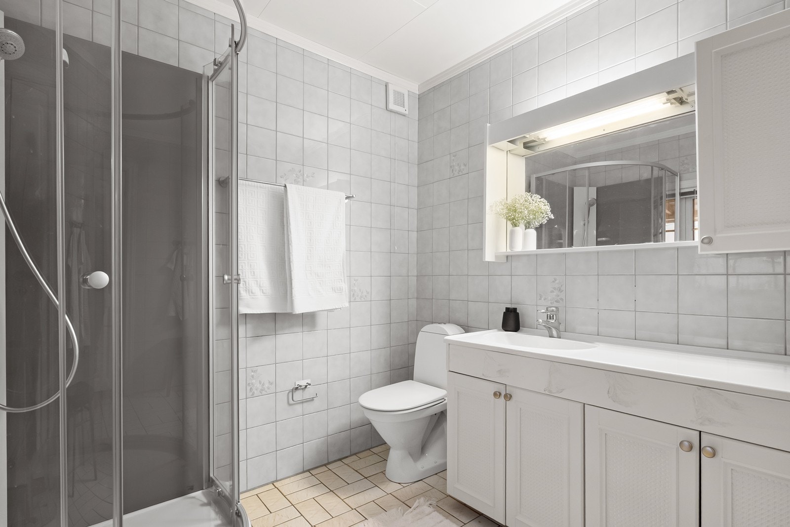 Badet er av ukjent alder og har grei størrelse. Rommet har flislagte overflater og har nyere dusjkabinett. Galleribilde