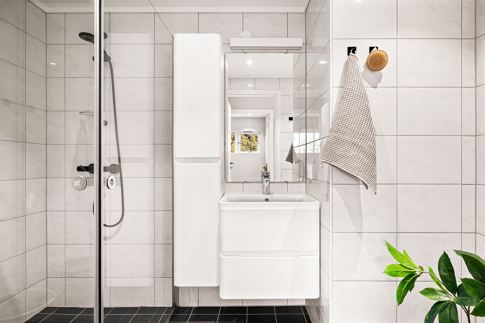 Badet er helfliset og fremstår moderne. Her er det varmekabler i gulv fra 2017 og innfelte downlights i tak. Galleribilde