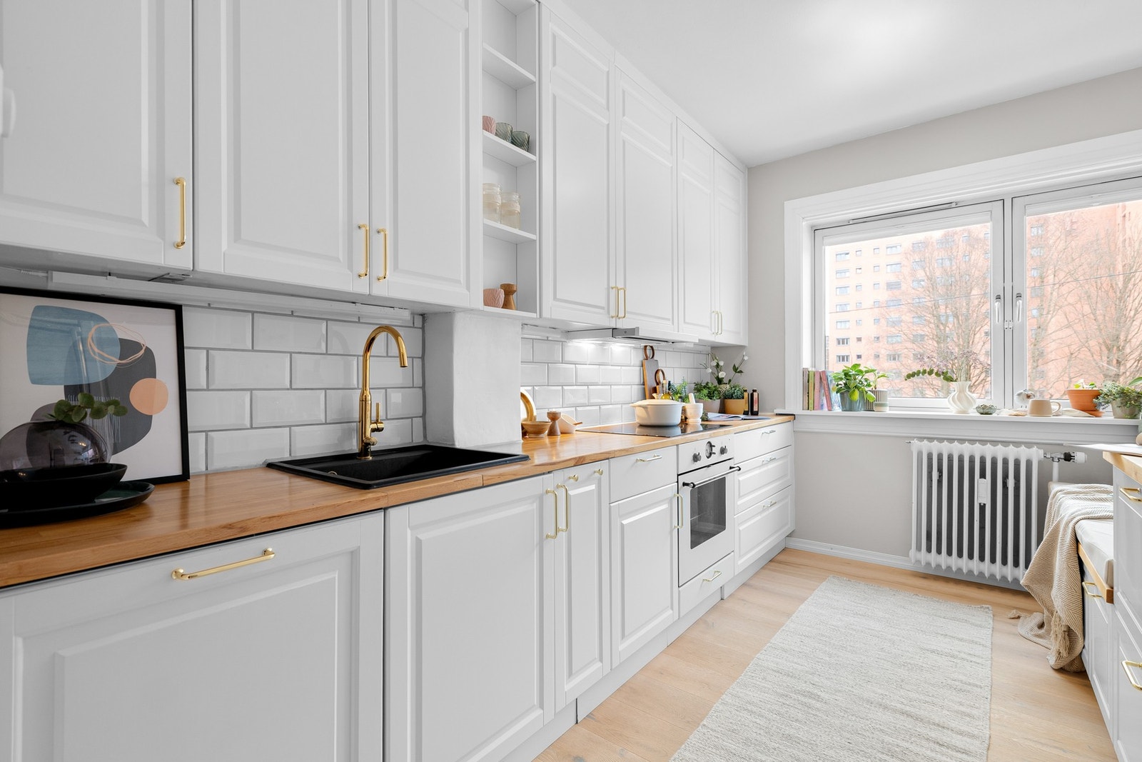 Innredningen har lyse profilerte fronter og benkeplate av tre med nedfelt oppvaskkum. Både fint og praktisk med lekre fliser i benkeryggen og belysning under overskapene. Galleribilde