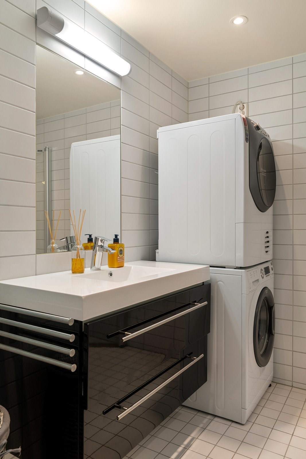 Badet er innredet med servant i baderomsinnredning, dusjhjørne, toalett og opplegg for vaskemaskin og tørketrommel. Galleribilde