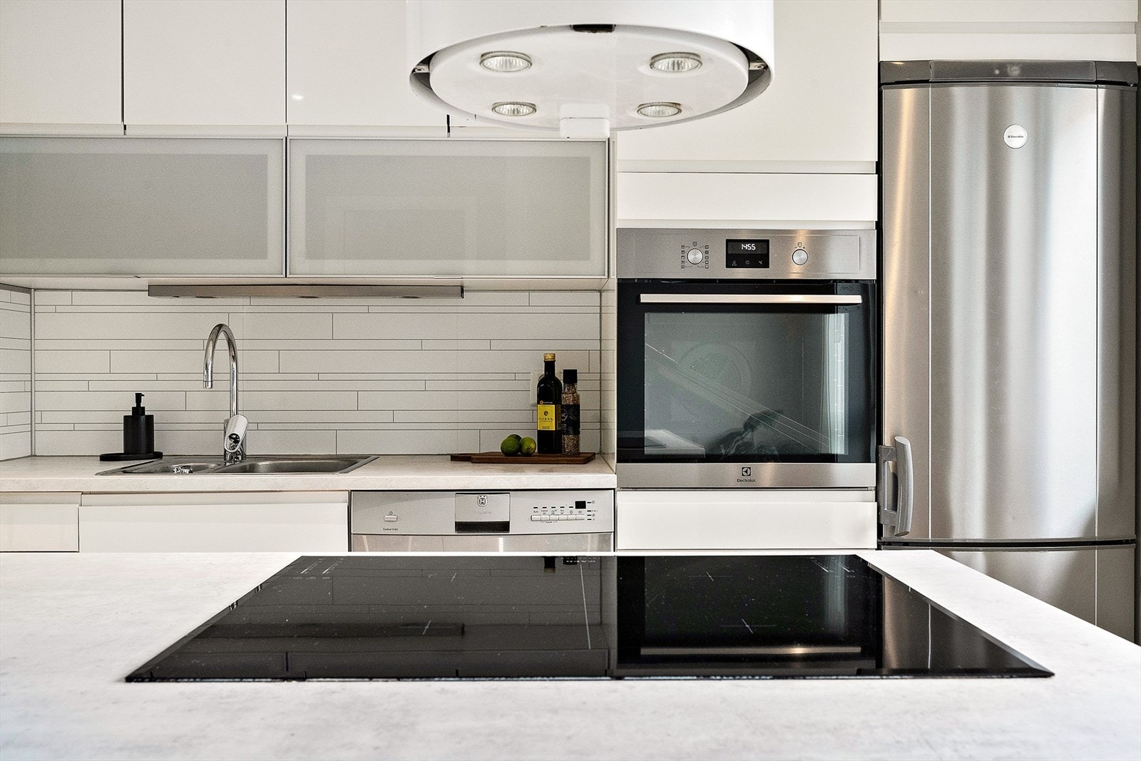 Kjøkkenet har fritthengende ventilator, bakerovn i riktig arbeidshøyde og indukskonsplatetopp nedfelt i kjøkkenøyen. Galleribilde