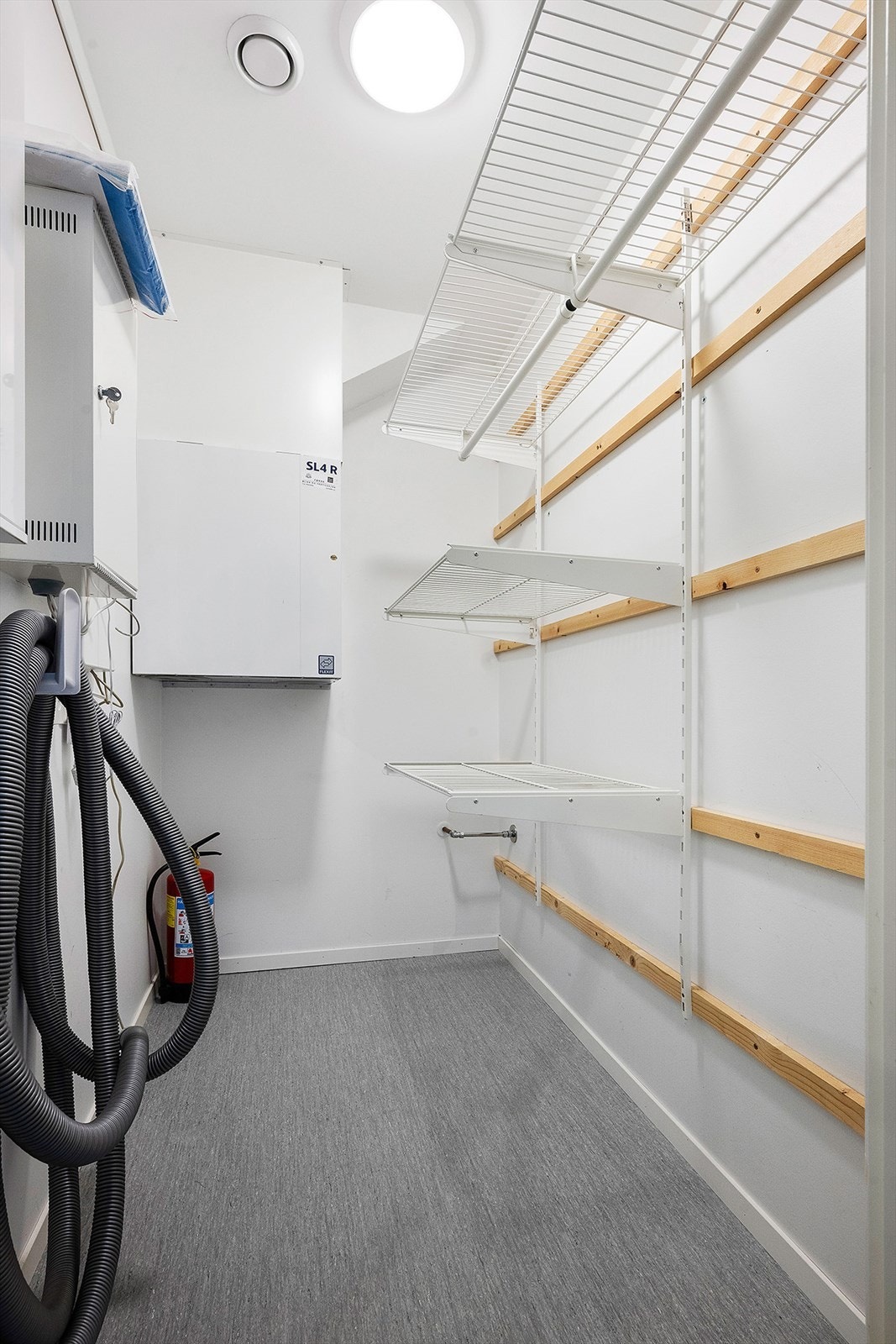 Boligen har innvendig og utvend bod. Her ser vi inneboden med hyllesystem og teknisk anlegg. Galleribilde