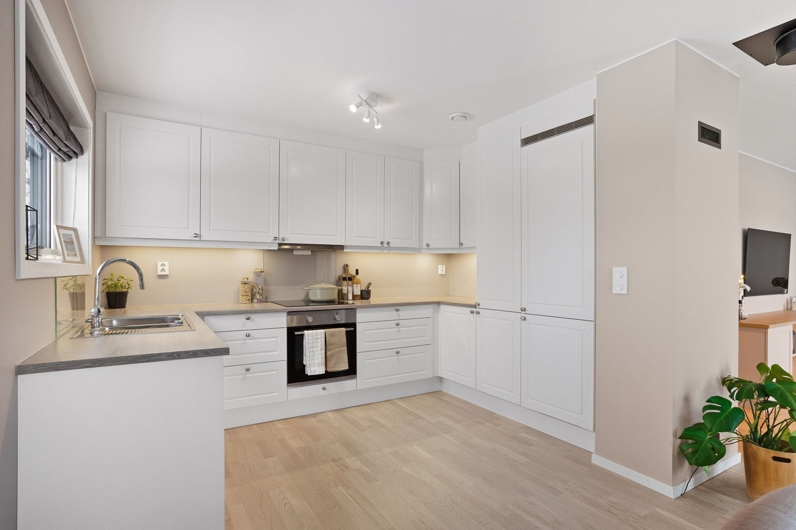 Lys og moderne kjøkkenløsning med rikelig skapplass og integrerte hvitevarer, ideelt for både daglig bruk og selskap. Galleribilde