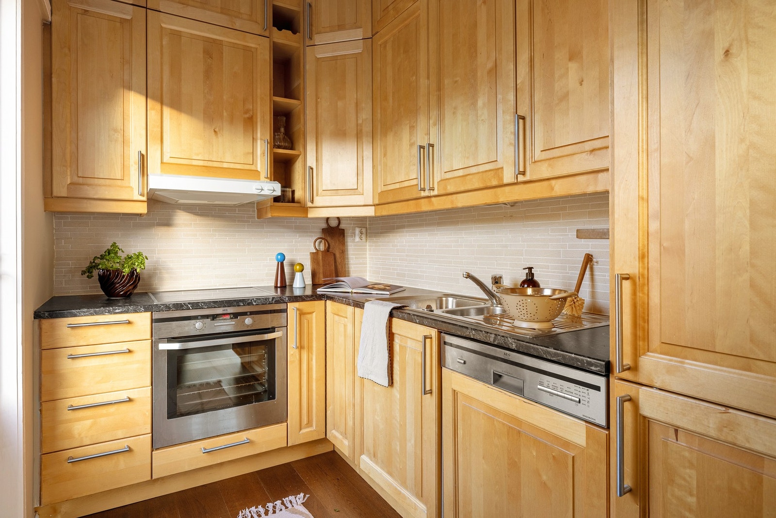 Det har laminat benkeplate med nedfelt vask av stål. Det er fliser mellom benkeplate og veggskap. Galleribilde