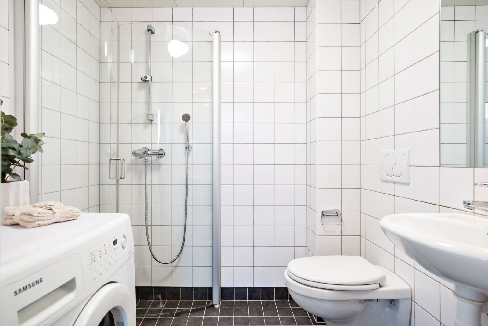 Utstyrt med innfellbare dusjdører, mekanisk avtrekk, opplegg for vaskemaskin, rørfordelingsskap, stoppekran, servant og veggmontert wc Galleribilde