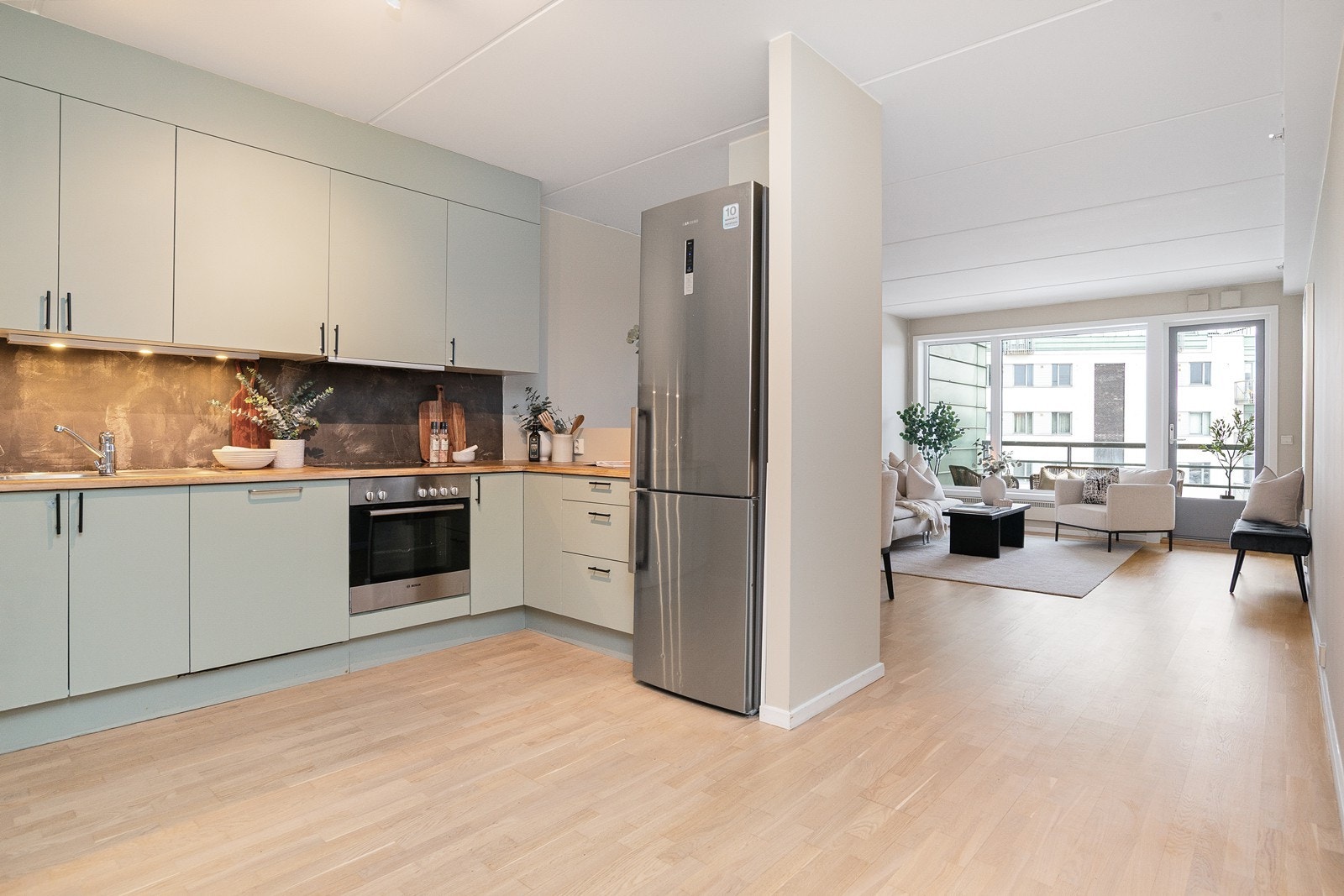 Kjøkkeninnredning fra Norema med glatte laminerte fronter og heltre benkeplate med nedsenket oppvaskkum Galleribilde