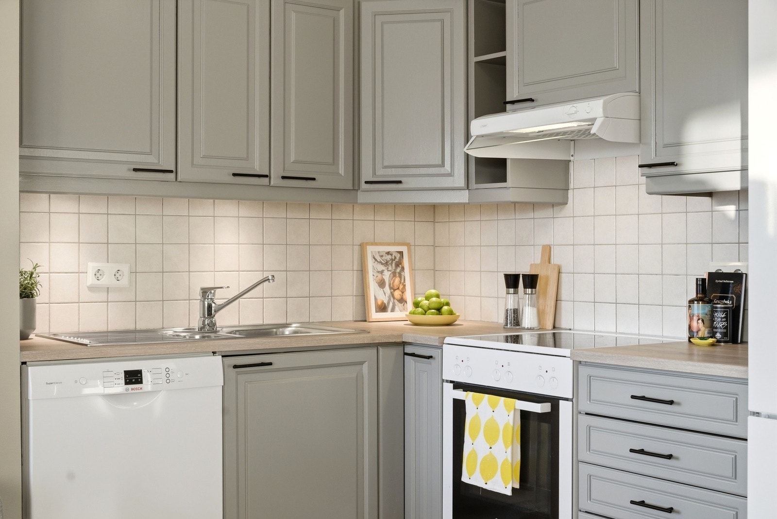 Kjøkkenet har profilerte fronter og fliser montert under overskap. Galleribilde