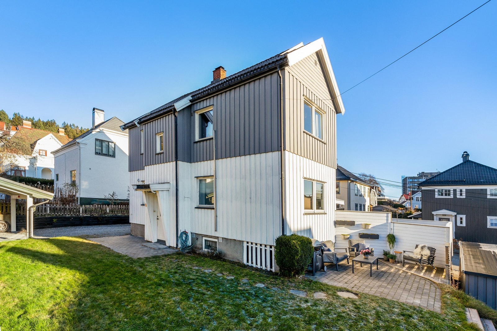 Seksjonen disponerer steinbelagt uteplass samt store deler av hagen på baksiden av boligen Galleribilde