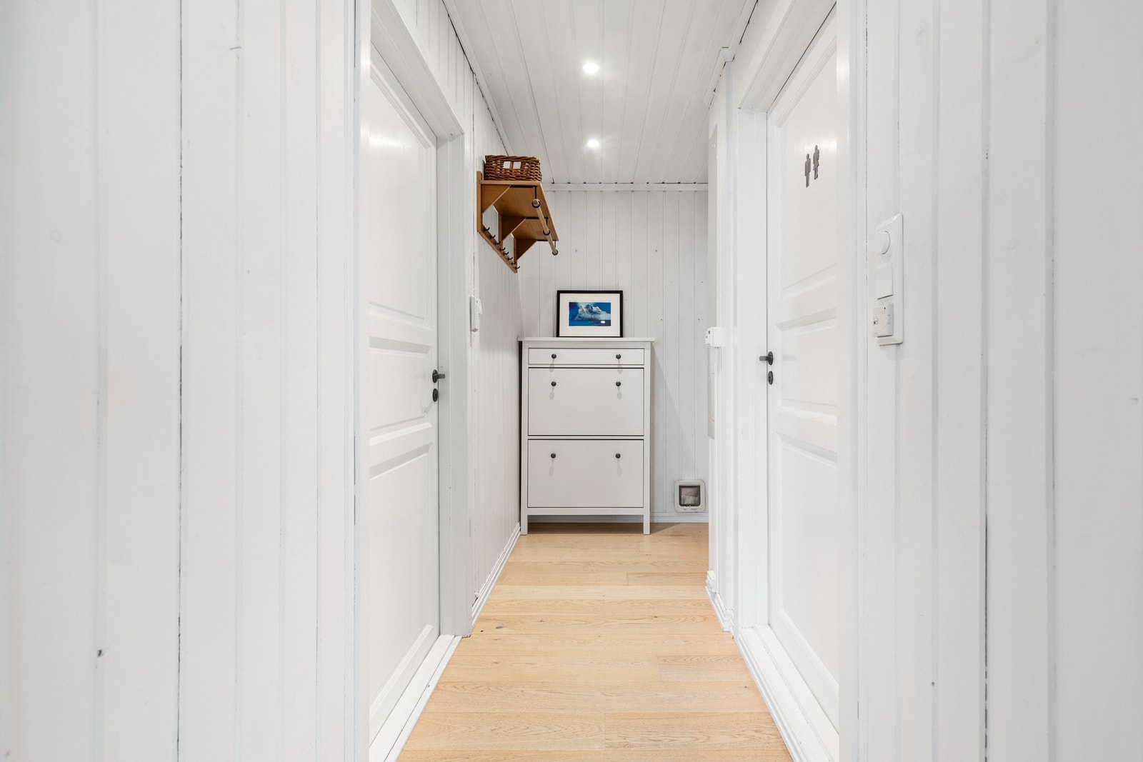 Entré med 1-stavs parkettgulv og malt panel på vegger og i himling Galleribilde