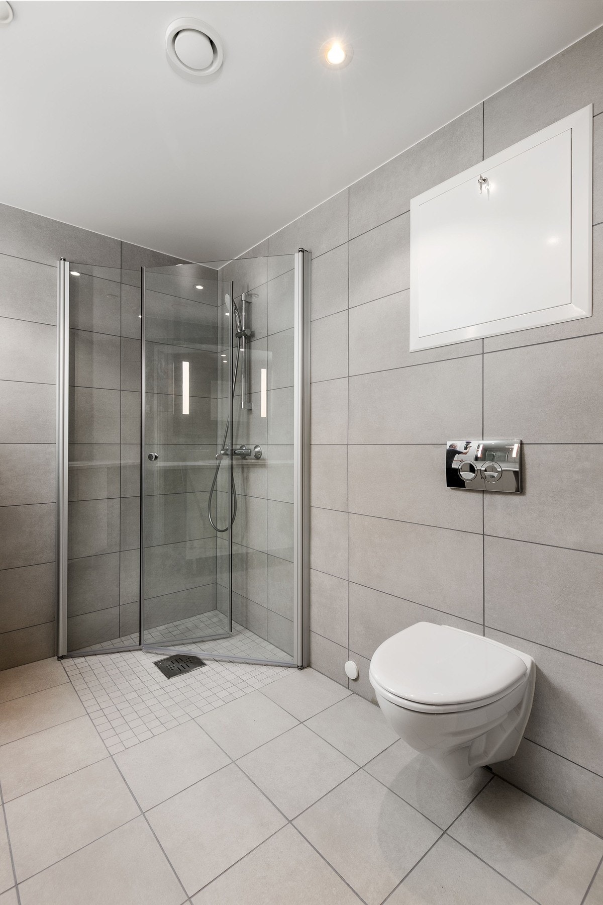 Badet har vegghengt toalett med innbygget sisterne, servant med skapinnredning samt speil med belysning. Galleribilde