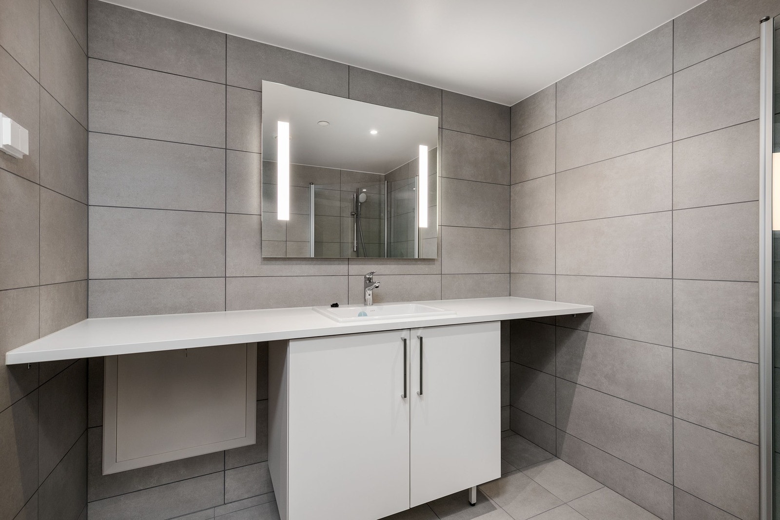 Delikat flislagt bad med alt man trenger for å få en fin start på dagen. Opplegg for vaskemaskin. Galleribilde